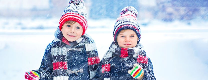 Two boys bundled up outside in the snow