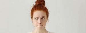 Redhead mom with hair in a bun and worried look on her face
