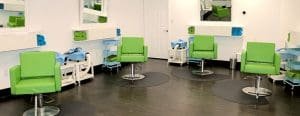 Lice clinic with individual stations set up, green chairs, blue carts and green and blue towels rolled up