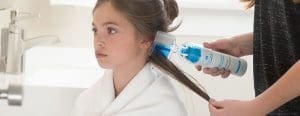 Mom using lice clinics of america lice preventer gel in daughters hair
