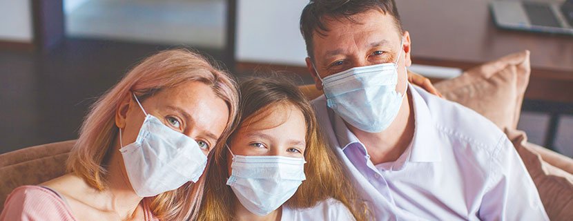 Happy family all wearing masks during the COVID pandemic