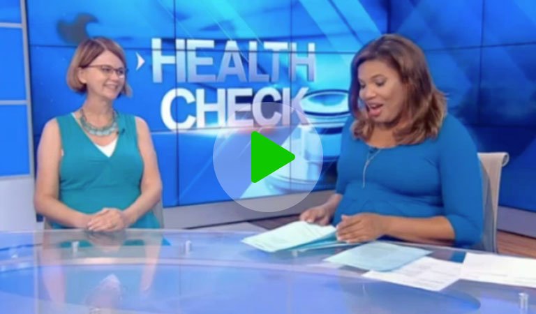 Clinic owner sitting on news set with broadcaster
