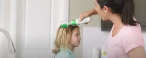 Mom applying lice clinics of america lice remover gel to sons hair