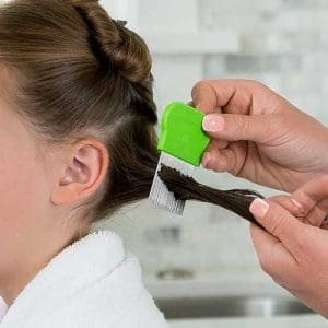 Mom using lice clinics of america lice comb in daughters hair